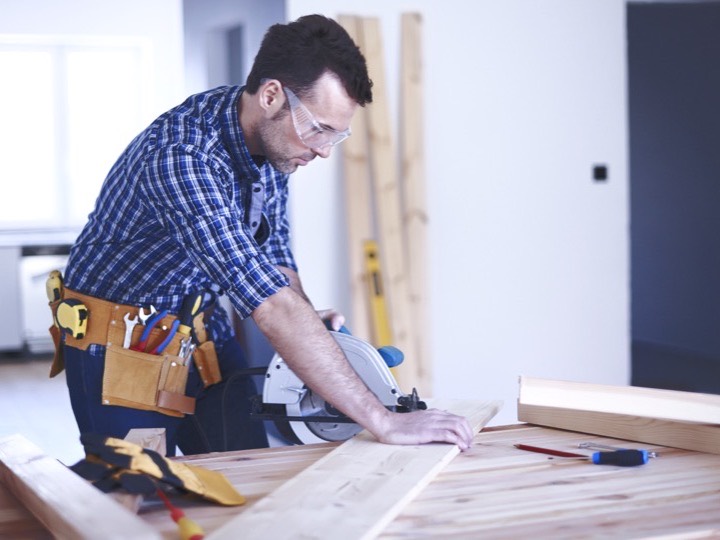 Carpenter cutting timber with a circular saw