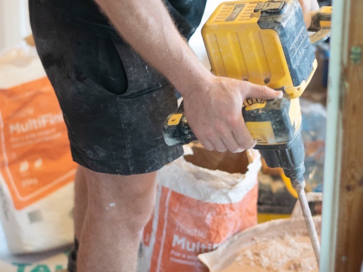 Plasterer mixing a bucket of multi-finish plaster